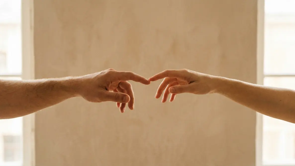 two hands reaching but not quite touching, representing how desperation creates distance