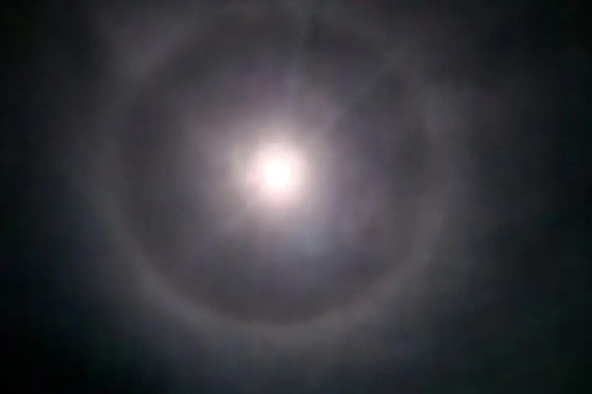 A complete 22-degree moon halo visible through thin high clouds